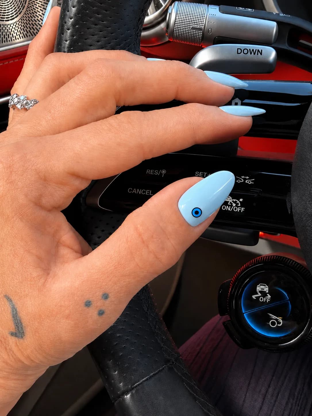 Baby-blue almond nails with a single evil-eye accent nail.